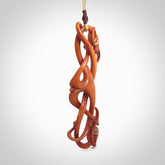 This necklace is carved from cow bone and stained with a homemade tea dye. It is a unique piece of wearable art that is sure to catch the eye. The shape is a complex twist form and has been beautifully hand carved by bone carver Yuri Terenyi.